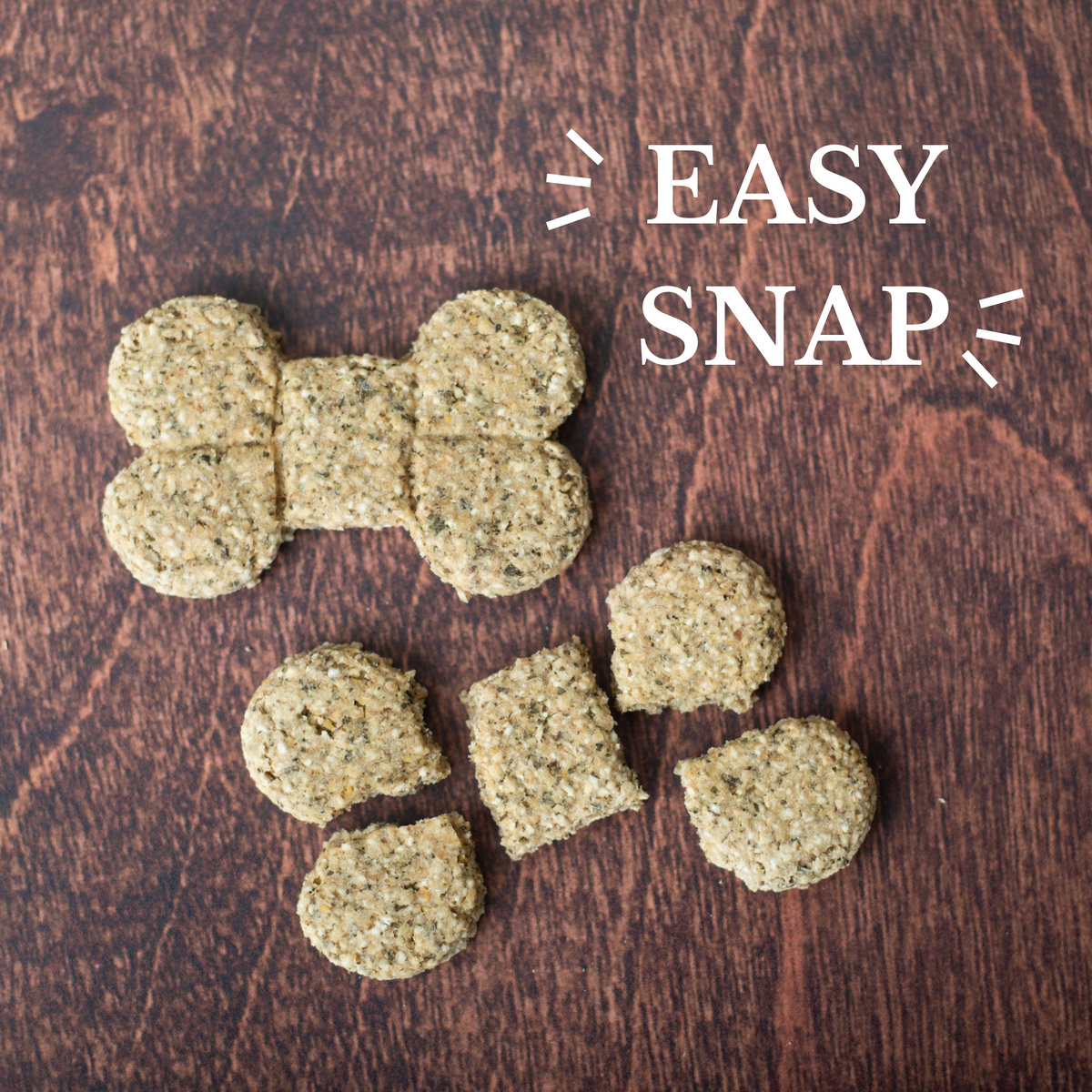 Two bone-shaped dog treats on a brown wood grain background. One is scored. The other is broken along the score lines into five smaller treats. The words EASY SNAP are in the top right hand corner.