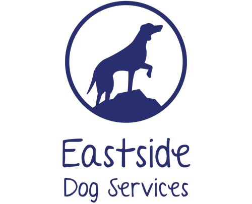 A dark blue logo featuring a silhouette of a dog standing on a rock inside a circle, with the text 'Eastside Dog Services' below on a plain white background.
